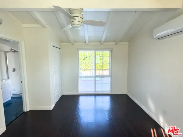 an empty room with wooden floor and a window