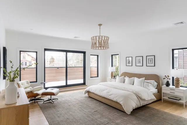 a spacious bedroom with a bed and a chandelier