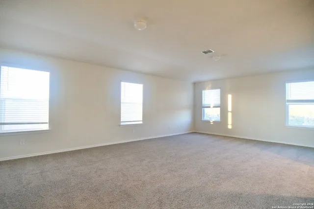 an empty room with windows and closet