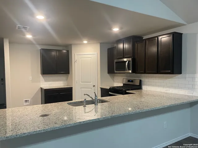 a kitchen with granite countertop cabinets and steel stainless steel appliances