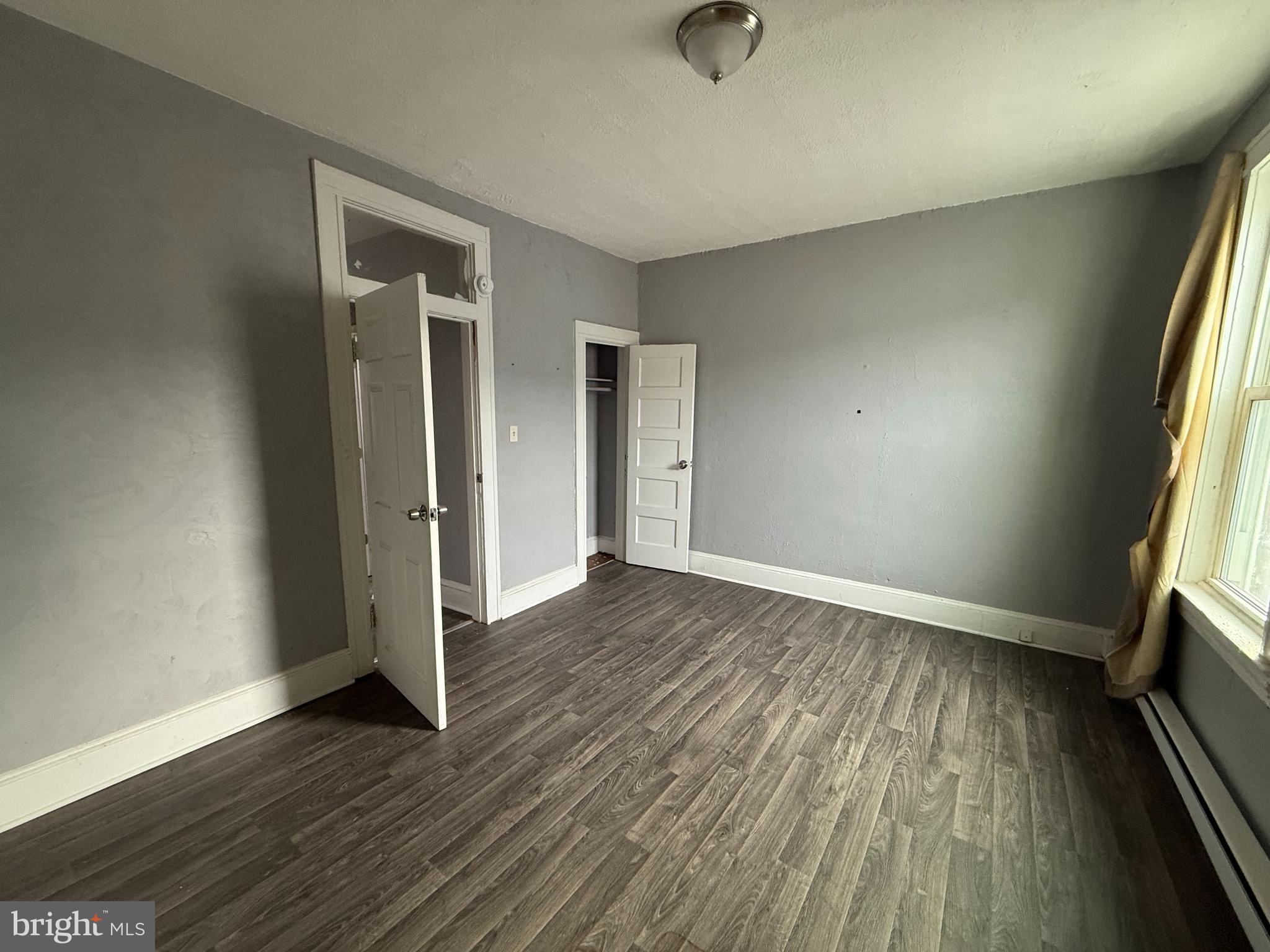 5313 Hamlin Avenue Baltimore, MD 21215 - Photo 13 of 14 an empty room with wooden floor and windows