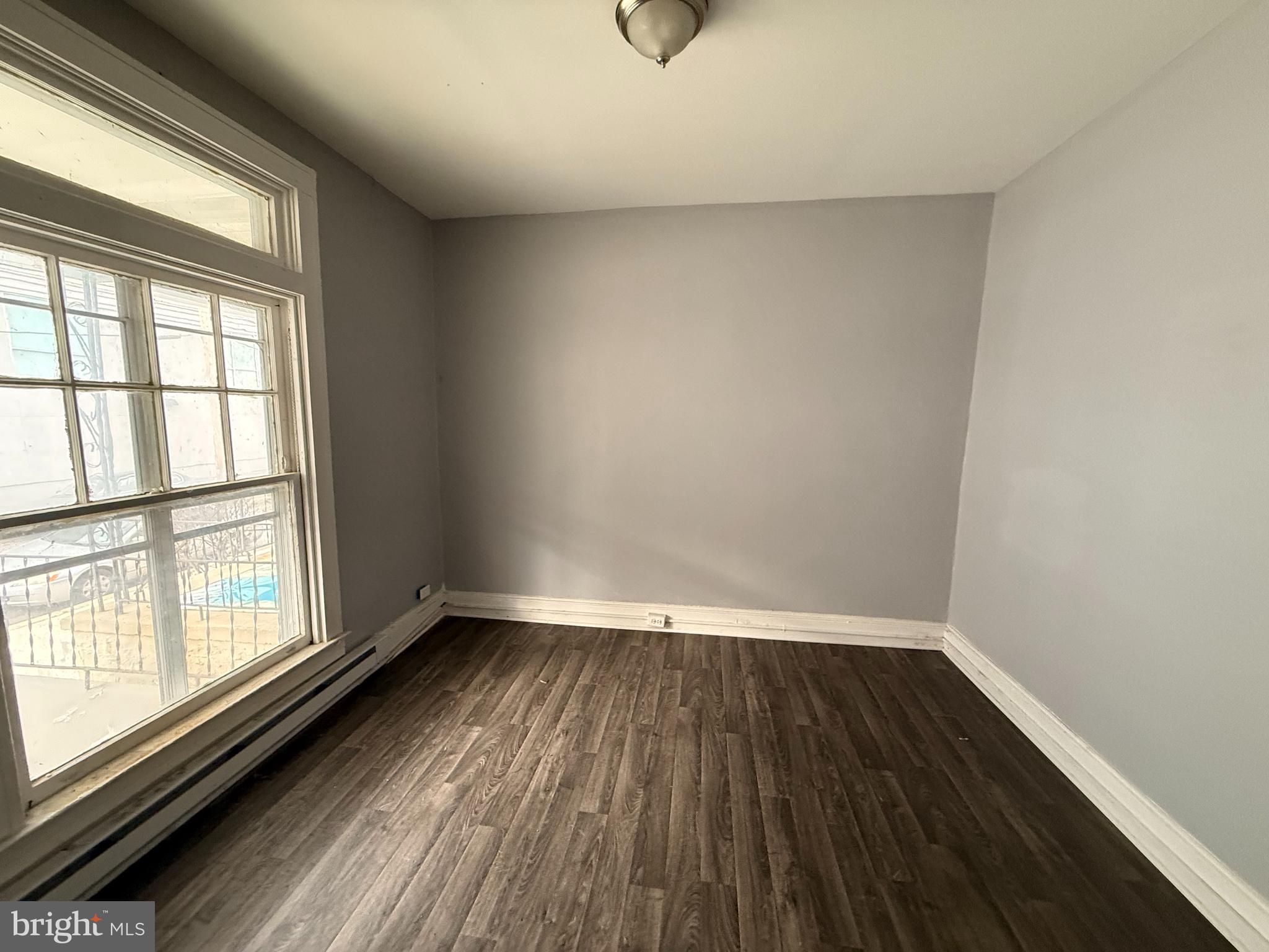 5313 Hamlin Avenue Baltimore, MD 21215 - Photo 3 of 14 a view of a room with wooden floor and window