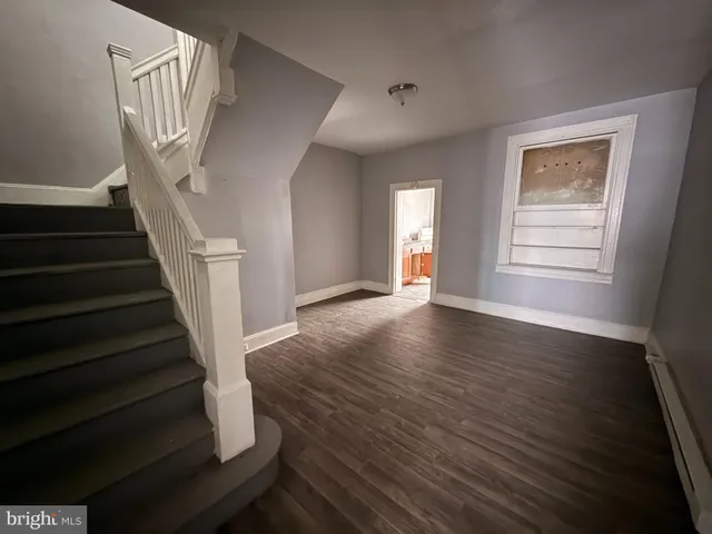 a view of an entryway with wooden floor and door