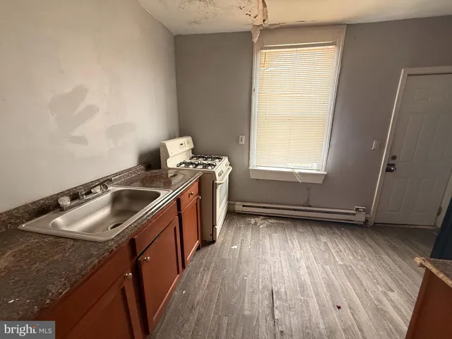 a kitchen with sink window and wooden floor
