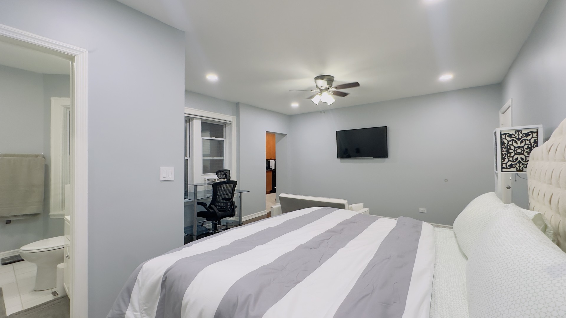 1411 West Farwell Avenue, Unit E2 Chicago, IL 60626 - Photo 13 of 27 a bedroom with a bed and a flat screen tv