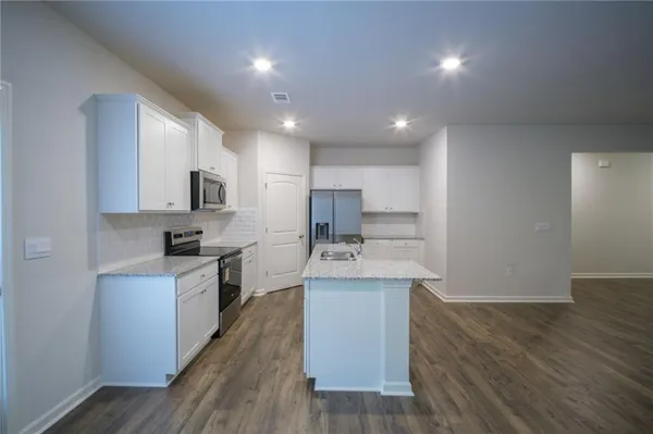 a kitchen with stainless steel appliances a sink stove and cabinets
