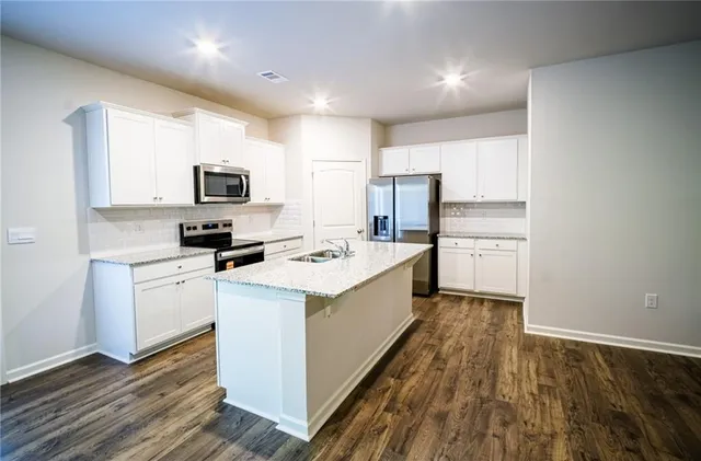 a kitchen with a sink a counter top space stainless steel appliances and cabinets
