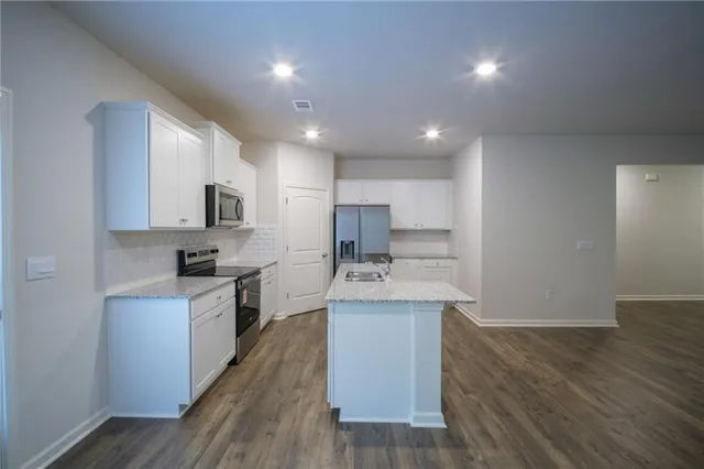 a kitchen with stainless steel appliances a sink stove and cabinets