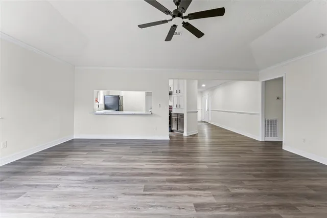 a view of empty room with wooden floor and window