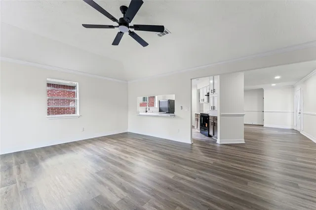 a view of empty room with wooden floor and ceiling fan