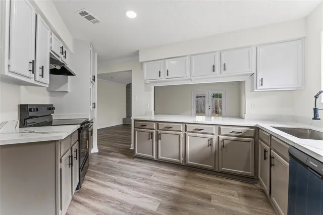 a kitchen with granite countertop a sink stove and cabinets