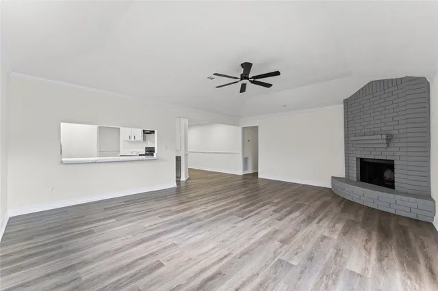a view of empty room with wooden floor and fireplace