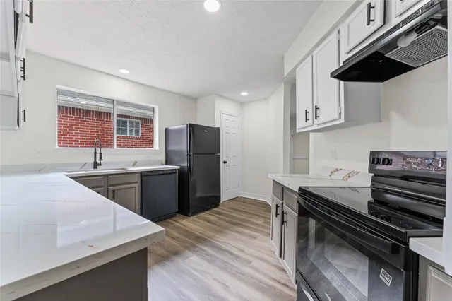 a kitchen with stainless steel appliances kitchen island a sink dishwasher a stove a refrigerator and cabinets