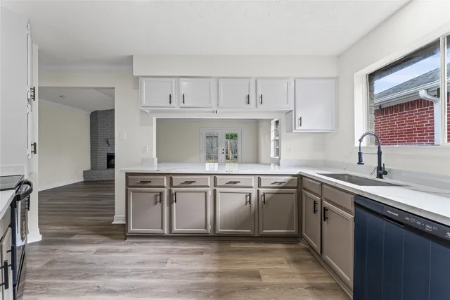 a kitchen with a sink cabinets appliances and a window