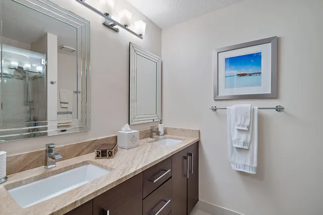 a bathroom with a double vanity sink a mirror and shower