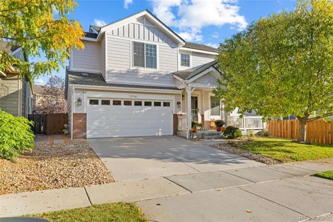 a view of a white house with large windows and a small yard