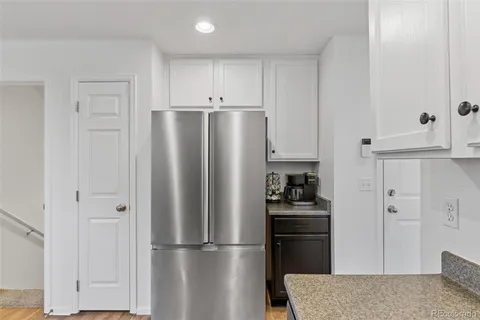 a kitchen with stainless steel appliances granite countertop a refrigerator and a stove top oven