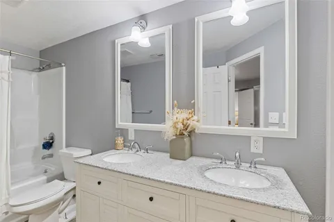 a bathroom with a granite countertop sink a toilet and a mirror