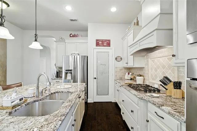 a large kitchen with stainless steel appliances granite countertop a sink a stove and a refrigerator