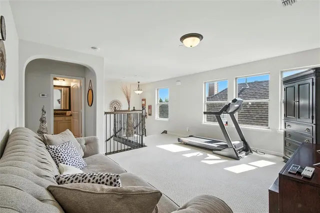 a living room with furniture a flat screen tv and a large window