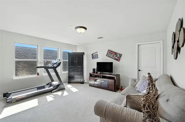 a living room with furniture gym equipment and a flat screen tv
