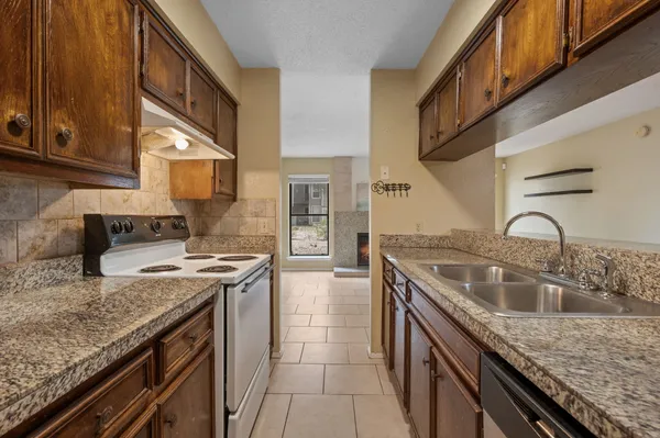 a kitchen with stainless steel appliances granite countertop a sink stove and cabinets