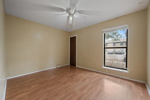 an empty room with windows and fan