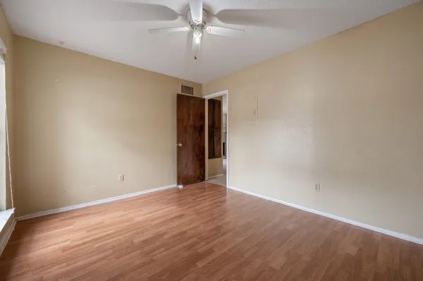 a view of an empty room with wooden floor