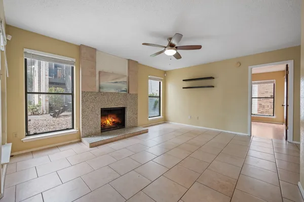 a view of an empty room with window and fireplace