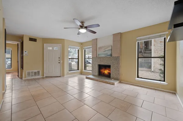 a view of an empty room with a fireplace and a window
