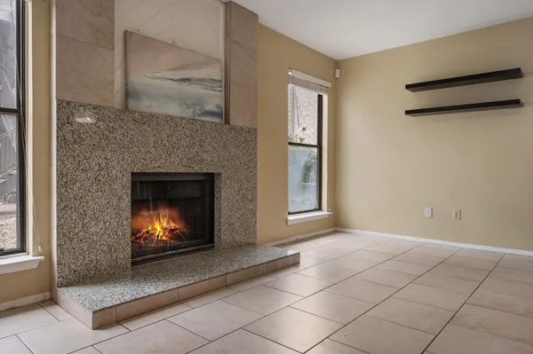 a view of an empty room with fireplace and a window