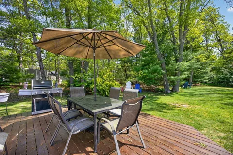a view of patio with chairs and table under an umbrella