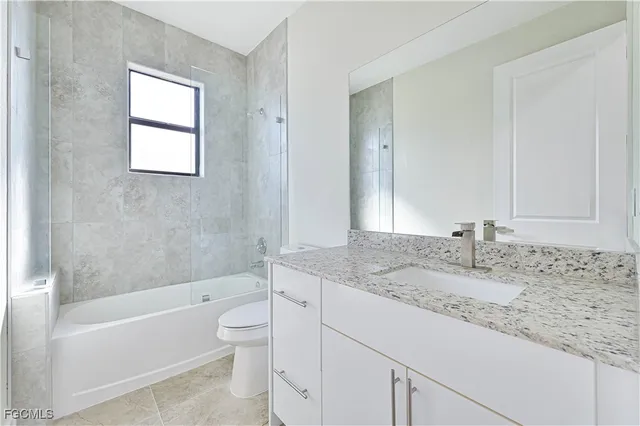 a bathroom with a granite countertop sink a toilet and bathtub