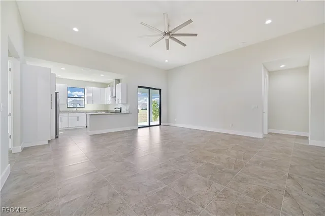 an empty room with fan and windows