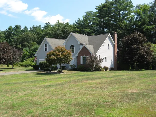 a front view of a house with a yard and trees