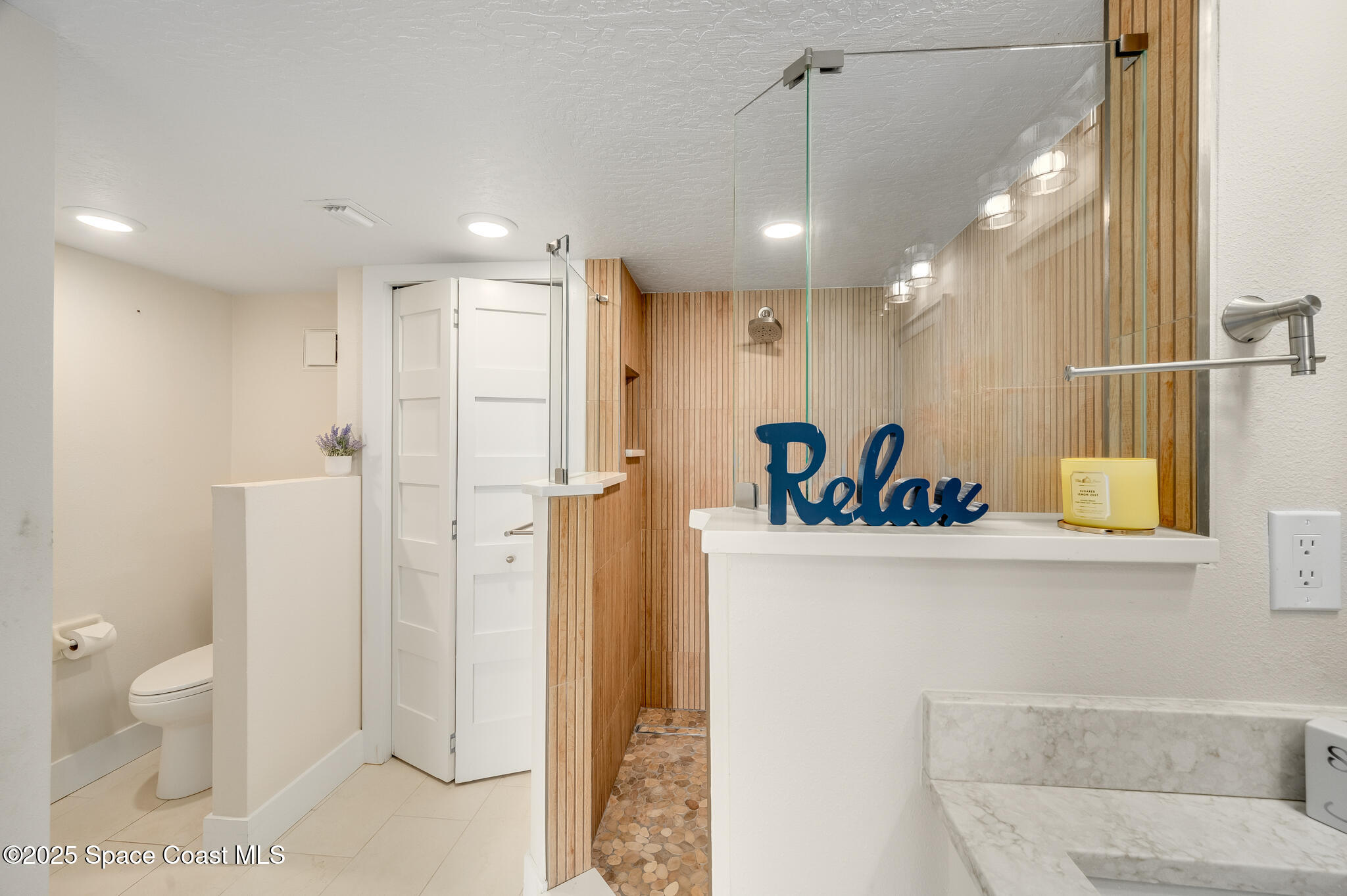 3220 River Villa Way, Unit 141 Melbourne Beach, FL 32951 - Photo 16 of 79 a view of a bathroom with a shower and a sink