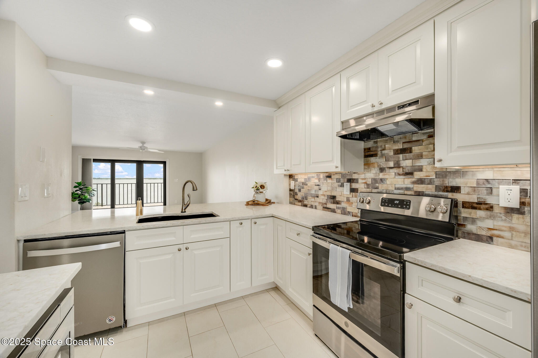 3220 River Villa Way, Unit 141 Melbourne Beach, FL 32951 - Photo 2 of 79 a kitchen with white cabinets stainless steel appliances and sink