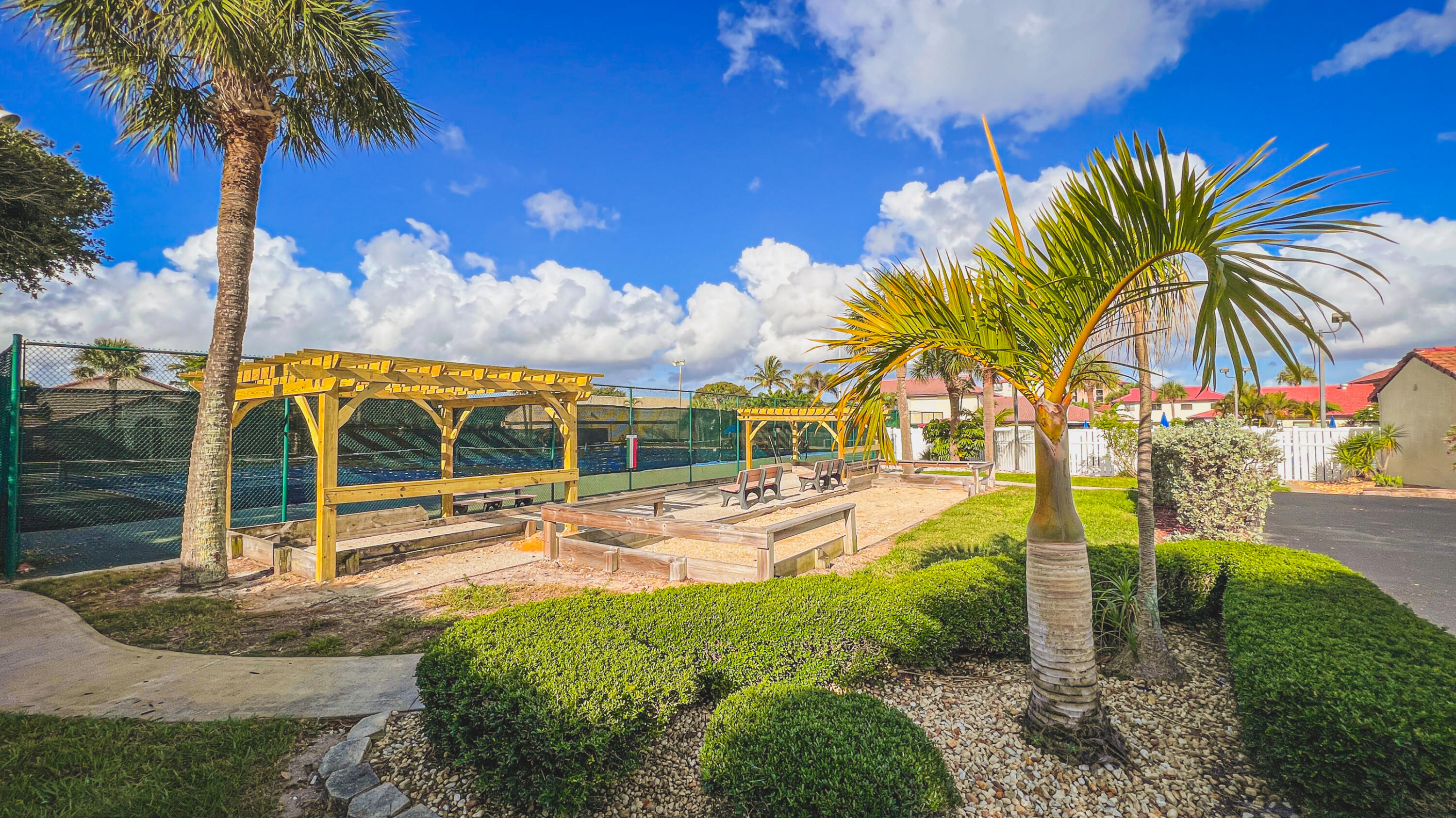 3220 River Villa Way, Unit 141 Melbourne Beach, FL 32951 - Photo 36 of 79 a view of a swimming pool with a lawn chairs under palm trees