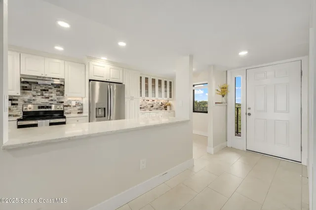 a view of a kitchen with a refrigerator and a sink