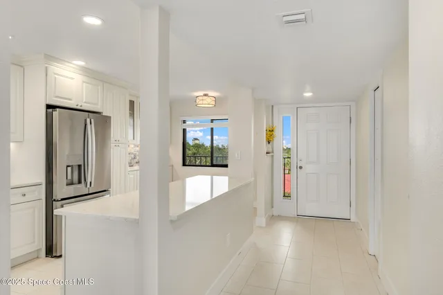 a view of kitchen with granite countertop cabinets and refrigerator
