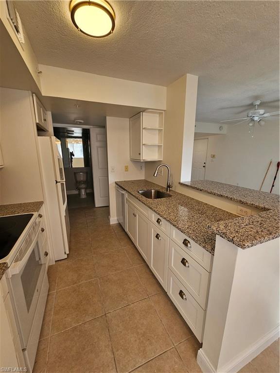 1840 Florida Club Circle, Unit 5206 Naples, FL 34112 - Photo 2 of 13 a kitchen with granite countertop a sink a stove and a refrigerator