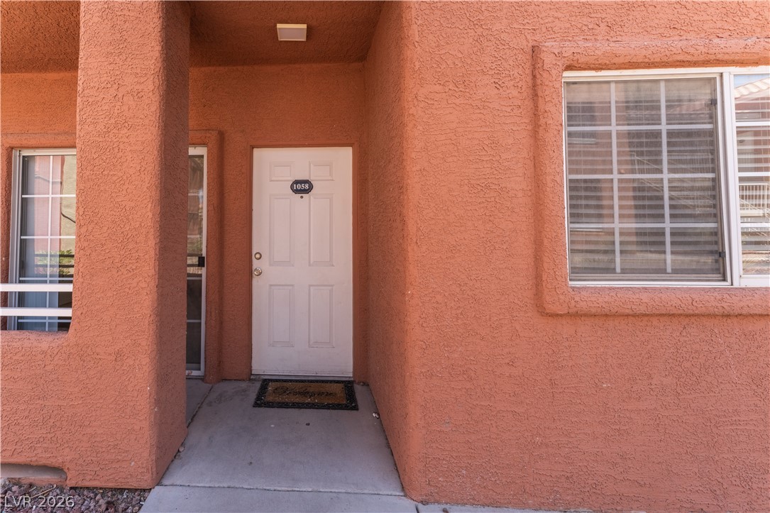 4730 East Craig Road, Unit 1058 Las Vegas, NV 89115 - Photo 3 of 30 A welcoming front entry awaits with textured stucco and a pristine white door.