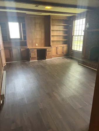 en empty room with windows and chandelier