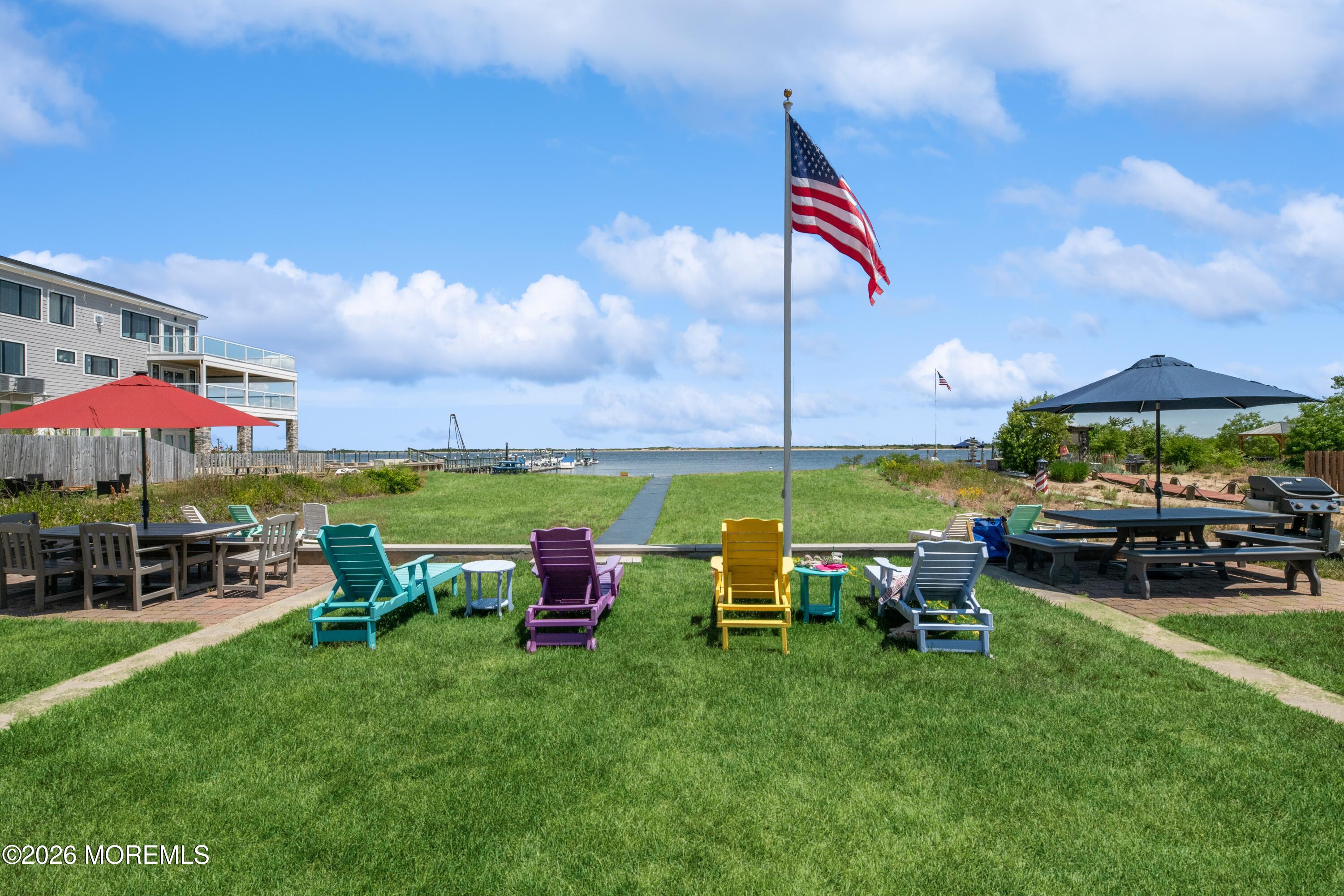 54 5th Street, Unit A Highlands, NJ 07732 - Photo 12 of 15 a view of a table and chairs under an umbrella in front of house