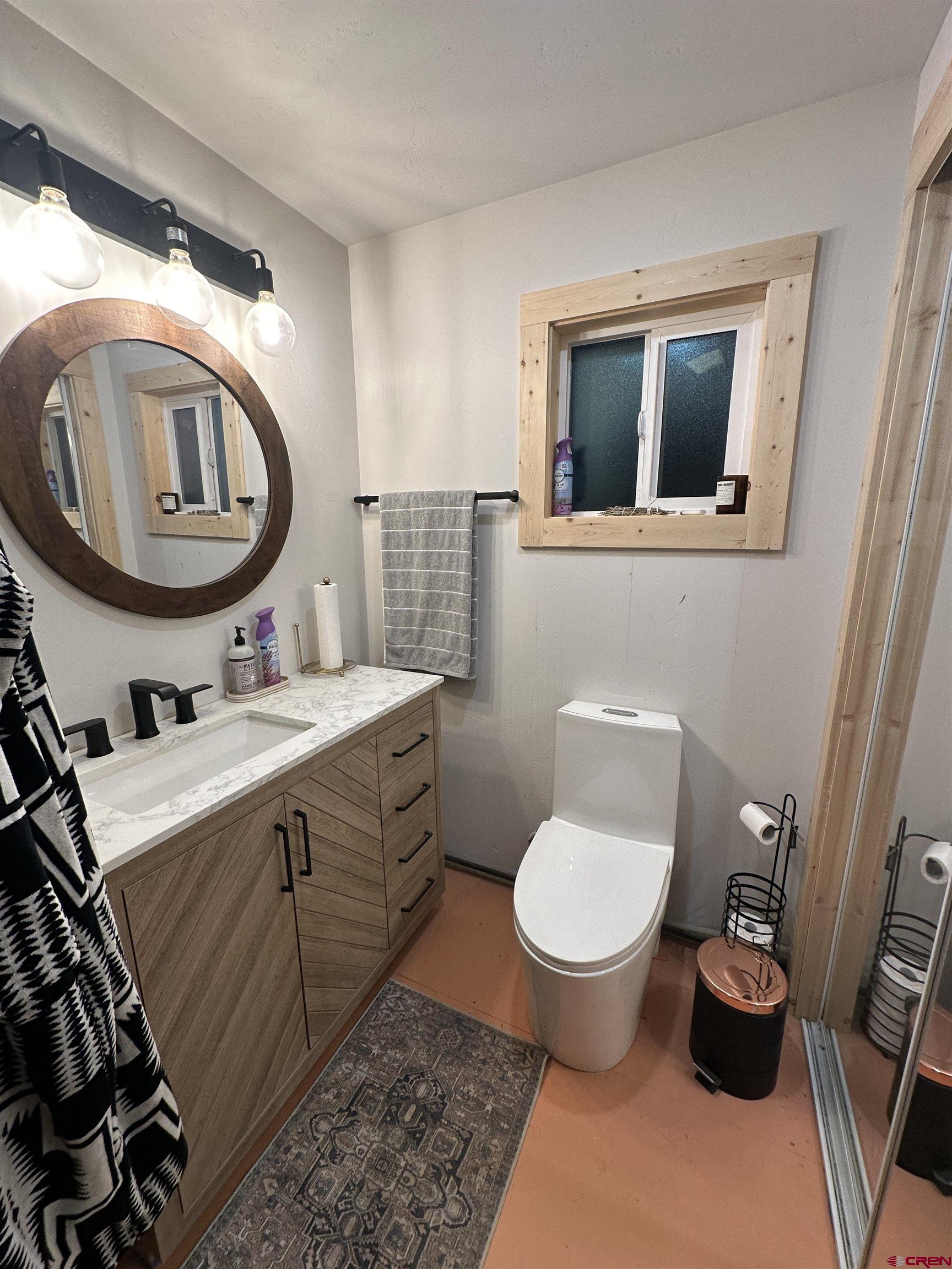 6493 Road 23.6 Cortez, CO 81321 - Photo 13 of 44 a bathroom with a toilet a sink and a mirror