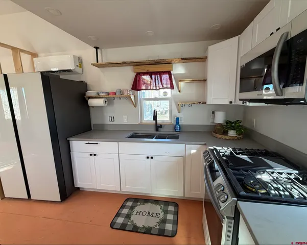 a kitchen with granite countertop a sink stainless steel appliances and cabinets