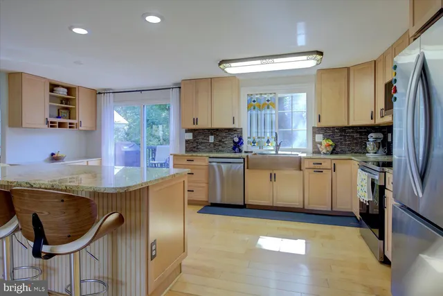 a kitchen with stainless steel appliances granite countertop a stove a sink and a refrigerator
