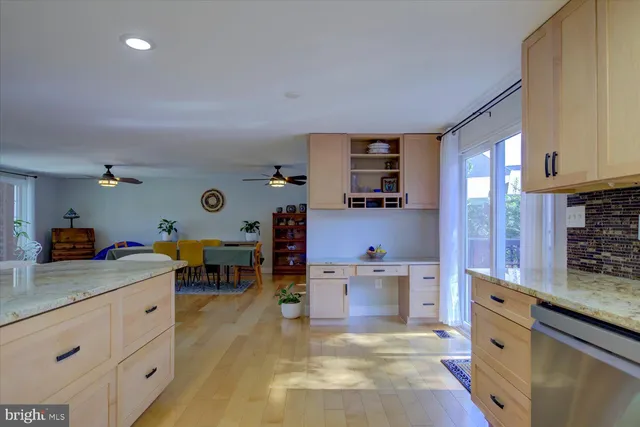 a kitchen that has a lot of cabinets in it and wooden floors
