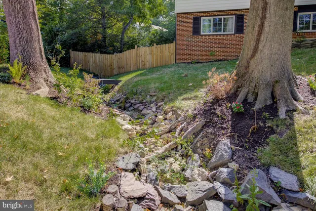 a backyard of a house with lots of plants and trees