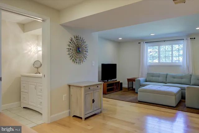 a living room with furniture a flat screen tv and a dresser